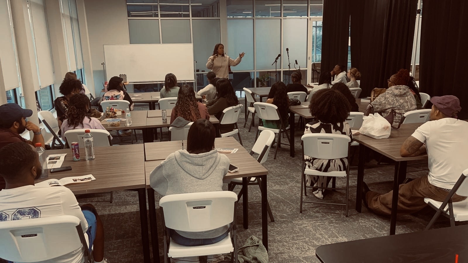 Annette teaching a room of participants seated together at tables